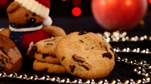 Árbol de Navidad, galletas con decoración, cono de pino sobre negro, abalorios, bokeh, luz, guirnalda, levas a la izquierda, primer plano — Vídeo de stock