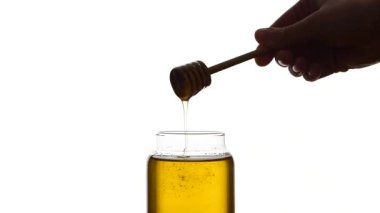 Cam Kavanoz bal tahta kaşıkla çöpleri hiç izole üzerinde beyaz, ağır çekim