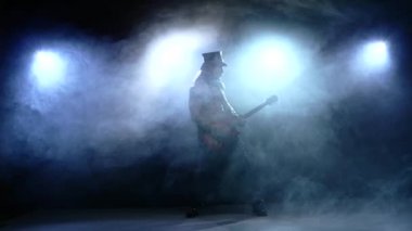 Genç adam bas gitar çalmaya şerit. Ağır çekim. duman