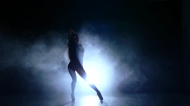 Красивая девушка с длинными черными волосами в черном купальнике сидит на полу, замедленное движение, дым — стоковое видео