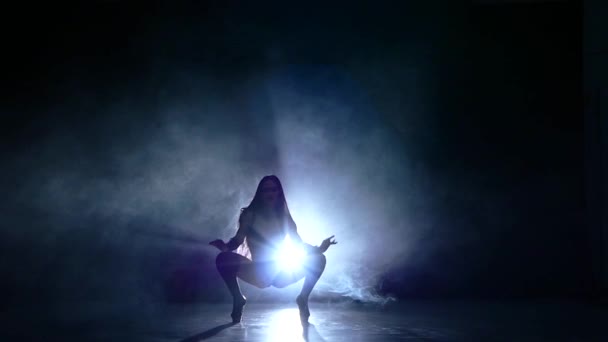 Сексуальна дівчина з довгим чорним волоссям у чорному купальнику сидить на підлозі — стокове відео