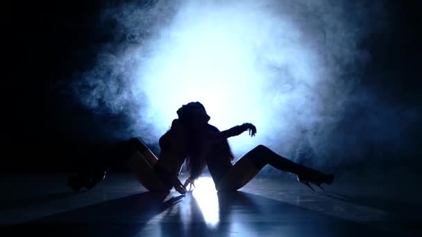 Две молодые сексуальные женщины тренируются на тёмном фоне. Медленные движения, дым — стоковое видео