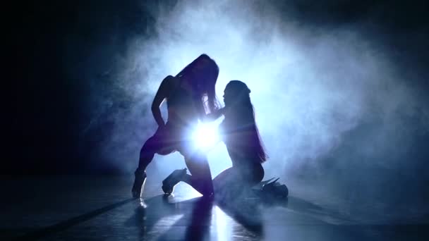 Dos jóvenes bailarinas de striptease sexy un fondo oscuro, cámara lenta, humo — Vídeo de stock