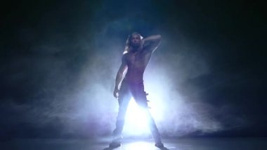 yerdeki genç adam striptizci dansçı. Ağır çekim, duman