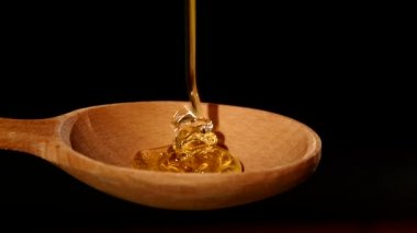 Siyah, ağır çekim üzerinde ahşap bal ayı üzerinden damlayan bal