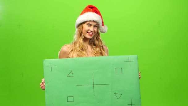 Sexy blonde Frau mit Weihnachtsmütze, grüne Leinwand, leeres Schild, Maske auf der Party, Neujahr — Stockvideo