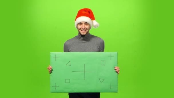 Feliz hombre guapo y brutal con sombrero de Navidad. pantalla verde, signo en blanco — Vídeos de Stock