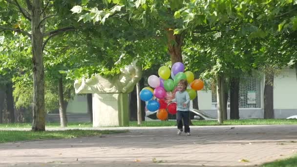 Bambina corre con palloncini multicolori, rallentatore — Video Stock