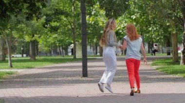 Genç kızlar eğleniyor ve bahar parkta atlama. ağır çekim