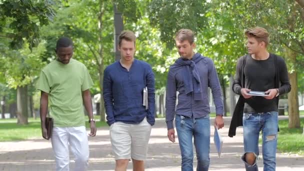 Szczęśliwi mężczyźni studenci chodzą razem na kampusie. Zwolnionym — Wideo stockowe