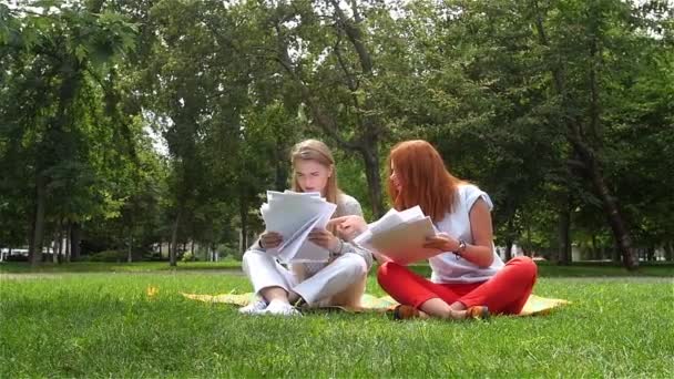 Vrouwen papier gooien in de lucht in park. Slow motion — Stockvideo