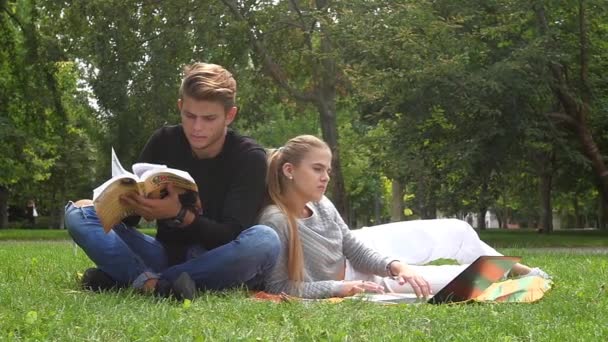 Paar kijken video en jongen met telefoon in een tablet in een groene veld. Slow motion — Stockvideo