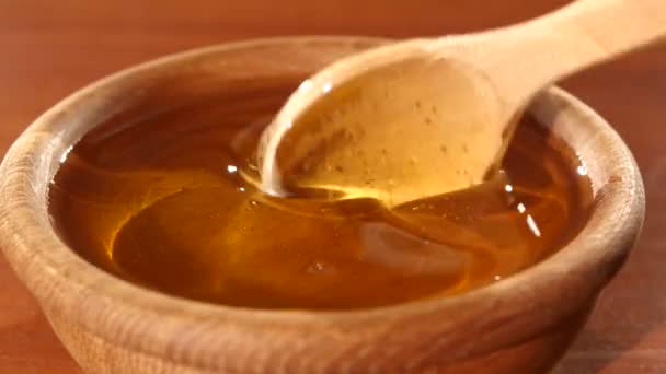 Taking honey by using spoon in wooden bowl — Stock Video