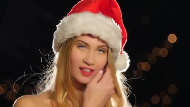 Красивая женщина в рождественской шапочке, изолированная на Черном, Боке, сексуальная блондинка, крупным планом — стоковое видео