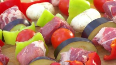 Kesme tahtası, rotasyon, yakın çekim, üst görünüm üzerinde barbekü için tavuk, domuz eti ve çeşitli sebzelerden çeşitli et