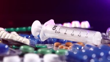 Her zamanki şırınga farklı haplar, rotasyon, yansıma, yakın, siyah, arka açık kırmızı ve mavi yatıyor