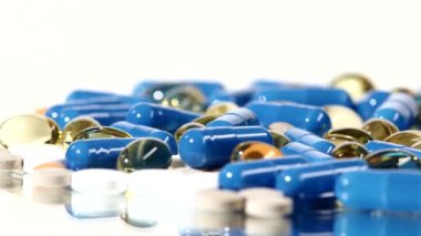 Tıbbi haplar, tabletler ve kapsüller, rotasyon, yansıma, yakın çekim, beyaz