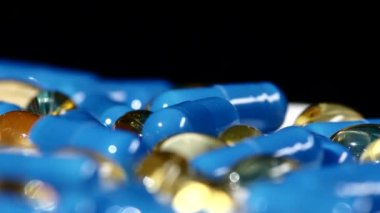 Tıbbi haplar, tabletler ve kapsüller, rotasyon, yansıma, yakın çekim, siyah