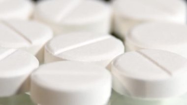 White pills, rotation, macro, on black