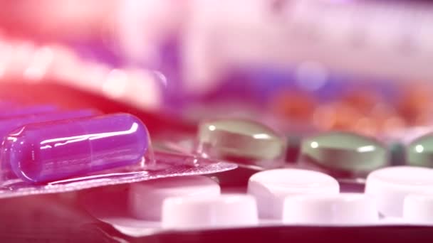 Деякі різні протизаплідні таблетки і два шприци, обертання, відображення, крупним планом, рожеве світло, динамічна зміна фокусу — стокове відео
