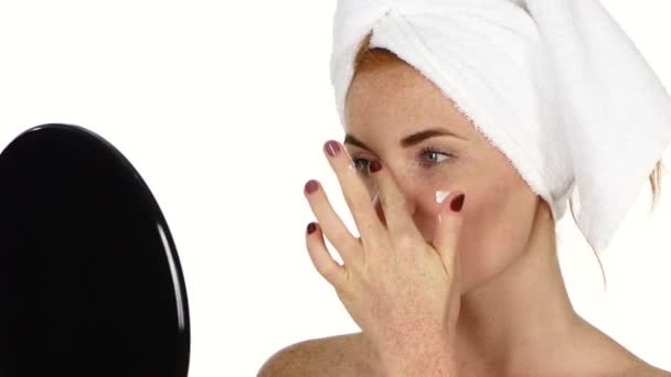 Mujer joven aplicando crema facial. Primer plano, baño — Vídeos de Stock