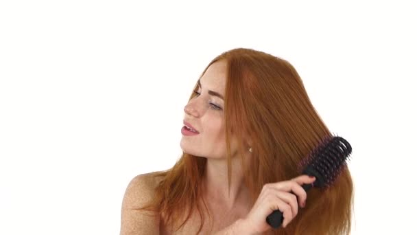 Красивая рыжая девушка расчесывает волосы. замедленное движение, крупный план, ванная комната — стоковое видео