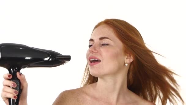 Smiling young Redhead girl singing while blow-dry. Close up. slow motion, bathroom — Stock Video