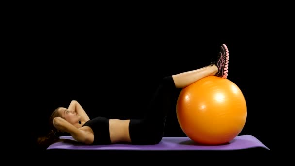 Mujer en traje de gimnasio haciendo ejercicio con una pelota de pilates, canal alfa, mate — Vídeo de stock