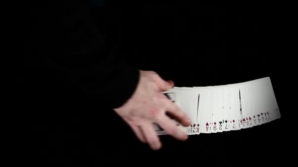 Játékkártyák terjedésének fekete felületen a bűvész, lassú mozgás — Stock videók
