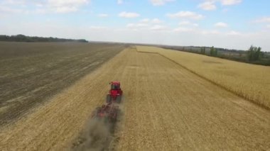 Kırmızı traktörçiftçi ekim için arazi hazırlanıyor. havadan çekim