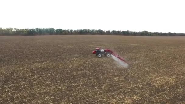 Червоний трактор оранки польової кукурудзи. повітряний постріл — стокове відео