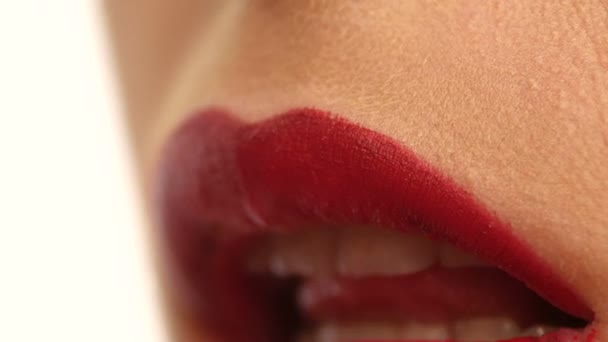 Blízká ženská ústa s jasným módním červeným lesklým make-upem
