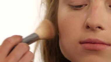 Makyaj sanatçısı güzellik kadın yüzüne ışıltı tozu uygulayarak. yakın kapatın. Yavaş çekim