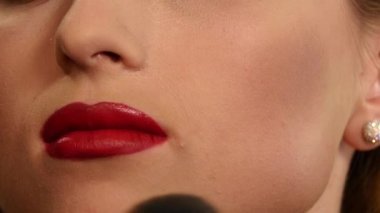 Makyaj sanatçısı kadın yüzüne ışıltı tozu uyguluyor. yakın kapatın. Yavaş çekim