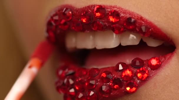 Luxe vrouw met red rhinestones op haar lippen. Slow motion. Close-up — Stockvideo