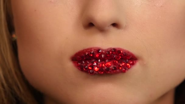 Mulher sexy com strass vermelho em seus lábios. Movimento lento. de perto — Vídeo de Stock