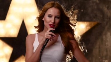 Mikrofonlu şık kız, kapalı gözler şarkı söylüyor. yavaş çekim, yakın çekim