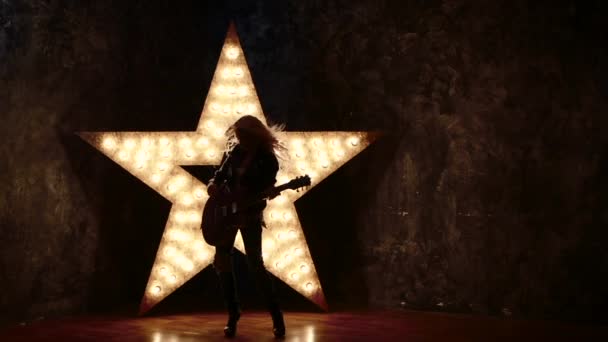 Young and beautiful rock girl playing the electric guitar, slow motion,  silhouette — Stock Video © KinoMasterDnepr #93956480