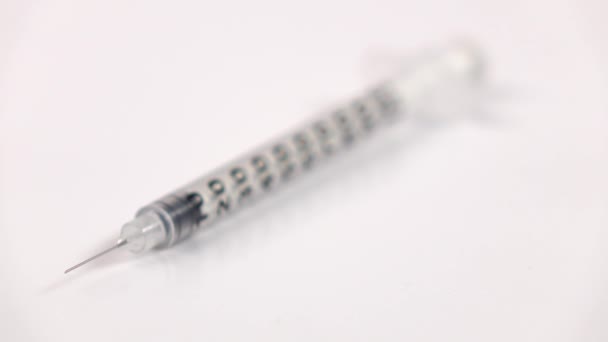Инсулиновый медицинский шприц на белом, динамическая смена фокуса — стоковое видео