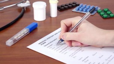 Hastanın tıbbi geçmişini ve tarama formunu yazan doktor