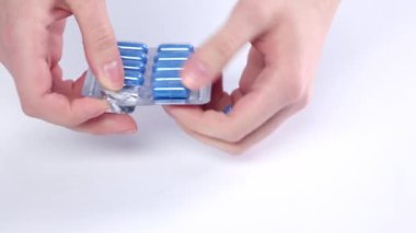Doktor eldeki mavi tıbbi hapları alıyor, yakından.