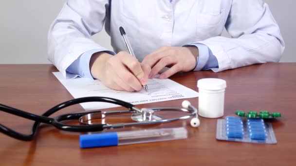 Médico escribiendo una historia clínica y un formulario de detección del paciente, vista frontal — Vídeo de stock