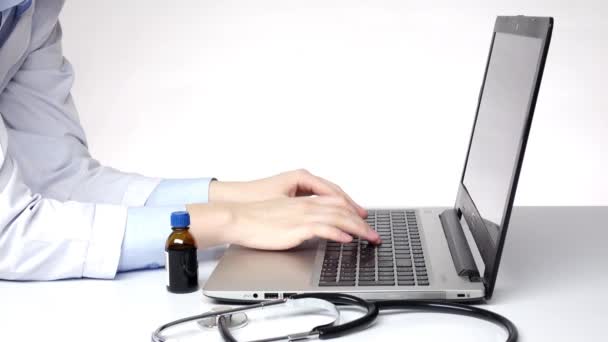 Dokter typen op de computer en zoeken naar iets, wit — Stockvideo