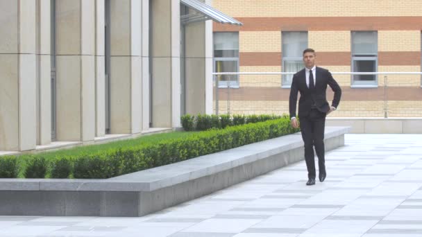 Un homme d'affaires attrayant fait le tour du bâtiment — Video