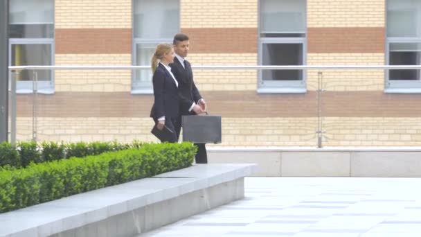 Zakenman en zakenvrouw lopen op de straat van een Business Center — Stockvideo