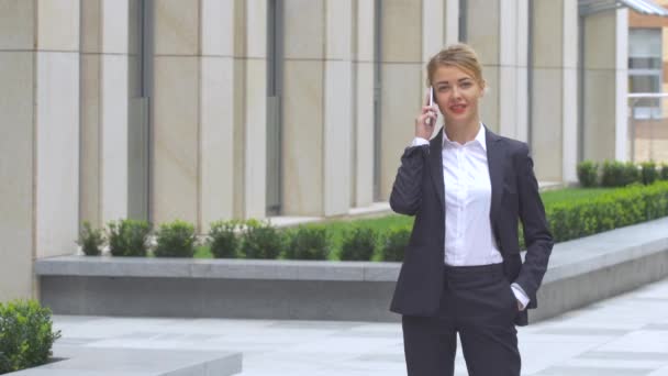 Hermosa mujer de negocios en el teléfono en el edificio moderno — Vídeo de stock