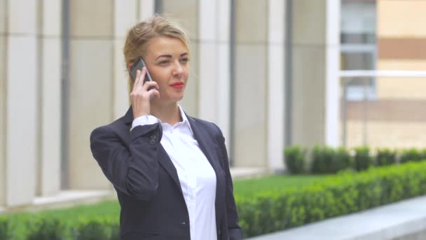 Belle femme d'affaires blonde au téléphone dans un immeuble moderne. Gros plan — Video