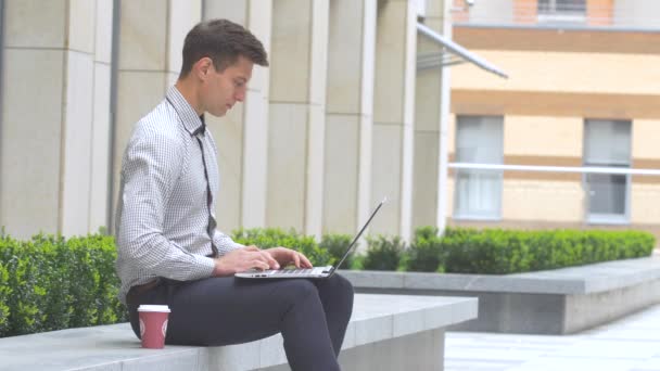 Homem de negócios sentado ao ar livre com laptop — Vídeo de Stock