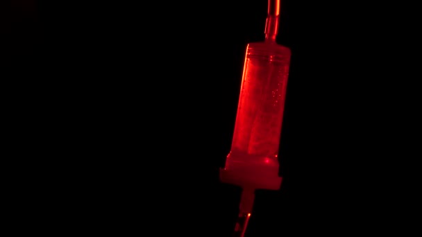 Drop counter with medicine, red light, highlights, on black — Stock Video