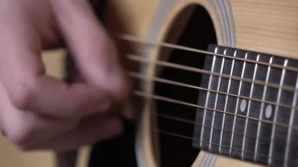 Чоловік грає на гітарі, фокусується на струнах, крупним планом — стокове відео